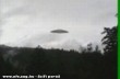 Egy teljesen jól kivehetõ UFO-t láthatunk egy erdõ felett lassan manõverezni